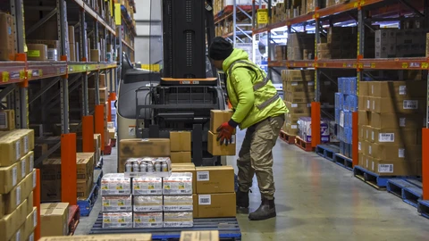 Logistiikka mies siirtää laatikkoa varastossa