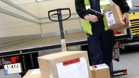 Mies skannaa laatikkoa rekassa