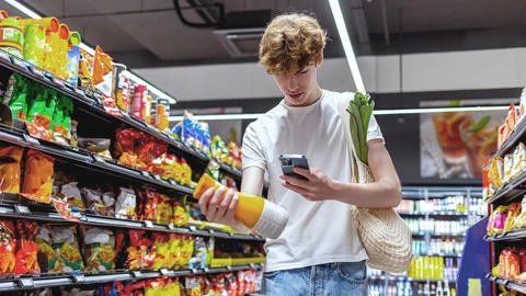 Poika skannaa tuoremehupullon 2D-koodia matkapuhelimellaan