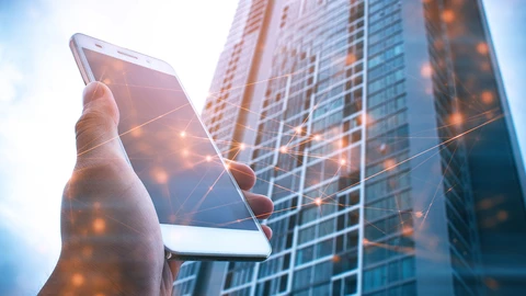 Matkapuhelin kädessä, dataa ja pilvenpiirtäjä