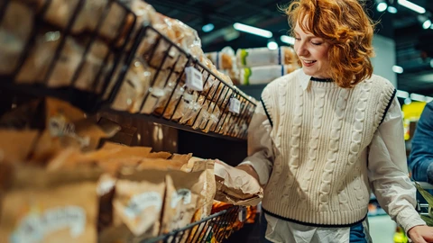 Nainen tutkii leipähyllyä myymälässä