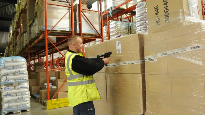 Mies skannaa laatikkoa varastossa