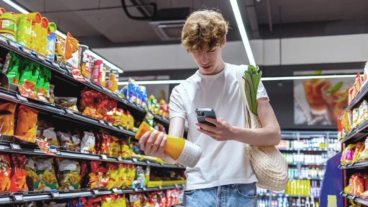 Poika skannaa tuoremehupullon 2D-koodia matkapuhelimellaan