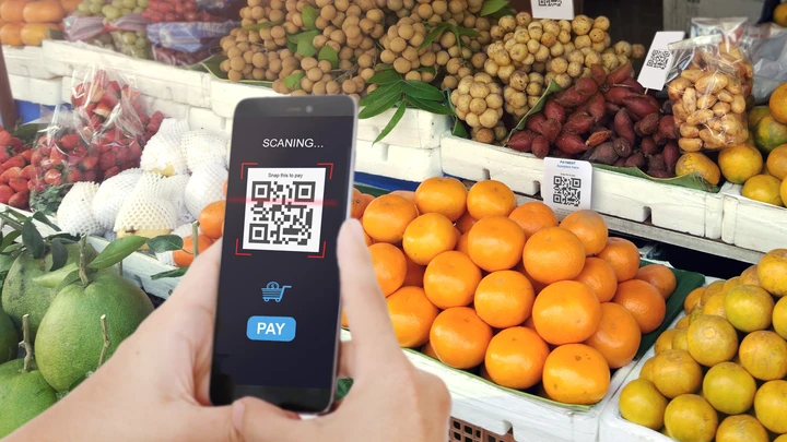 2D-koodi matkapuhelimessa hedelmähyllyn edessä